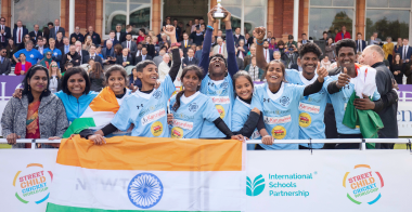 Team of students celebrating and holding a trophy.